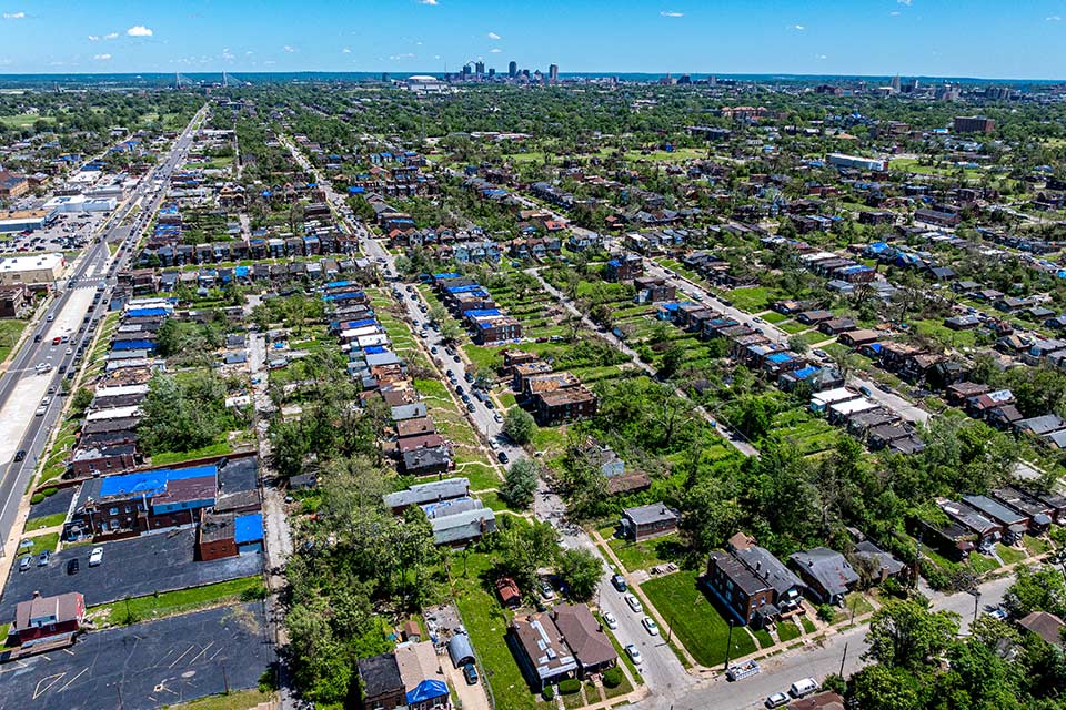Aerial view of an area in north St. Louis impacted by the May 16, 2025, tornado. Blue tarps on numerous rooftops are visible. Patches of greenery are interspersed throughout, with a skyline of downtown far in the distance. Aerial view of an area in north St. Louis impacted by the May 16, 2025, tornado. Blue tarps on numerous rooftops are visible. Patches of greenery are interspersed throughout, with a skyline of downtown far in the distance.