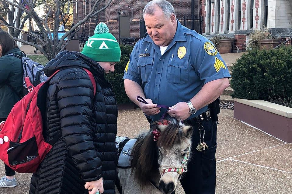 Sgt. Mike Otten (right) wrangles Winnie, a minature therapy horse, as part of a De-Stress with DPS event in December 2018.