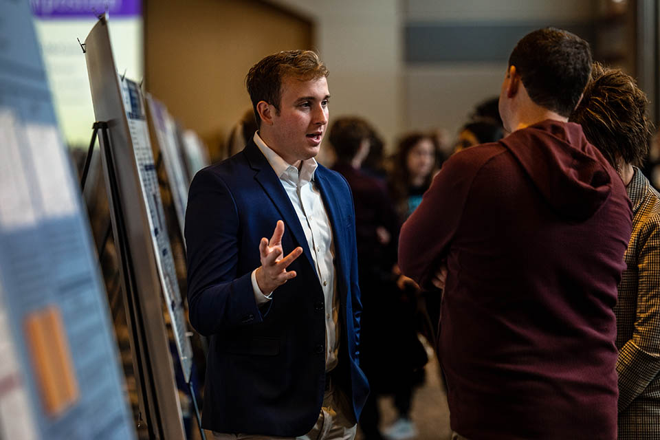 Kade Johnson explains his project “Energy Density of Tachyons and Gravitational Fields: A Study Using Schwarzschild Metric” during the Senior Legacy Symposium on May 2, 2023. Photo by Sarah Conroy. 