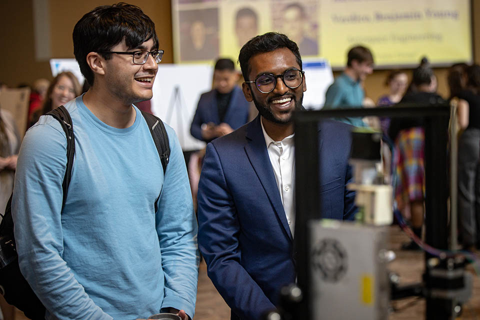 Aakash Nagarapu right, explains his team’s project “Customizable Bioprinting Using Photo-Crosslinked Hydrogels” during the Senior Legacy Symposium on May 2, 2023. Photo by Sarah Conroy. 