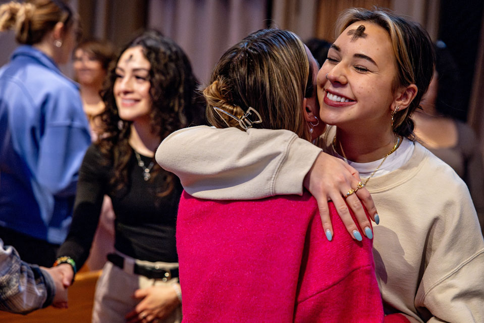 Members of the SLU share a hug during Ash Wednesday Mass at St. Francis Xavier College Church on Wednesday, Feb. 14. Photo by Sarah Conroy.