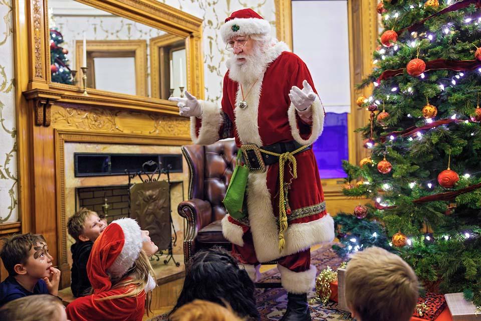 Santa speaks to a group of children near a Christmas Tree at Christmas on the Quad. Photo by Sarah Conroy.