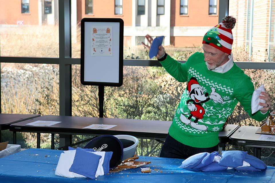 Scott Sell, Ph.D., professor of biomedical engineering and associate dean for undergraduate education in SSE, reacts as a gingerbread house collapses from the weight of the sandbags. Photo by Joe Barker.