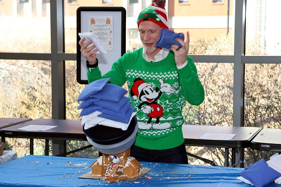 Scott Sell, Ph.D., professor of biomedical engineering and associate dean for undergraduate education in SSE, reacts as a gingerbread house collapses from the weight of the sandbags. Photo by Joe Barker.