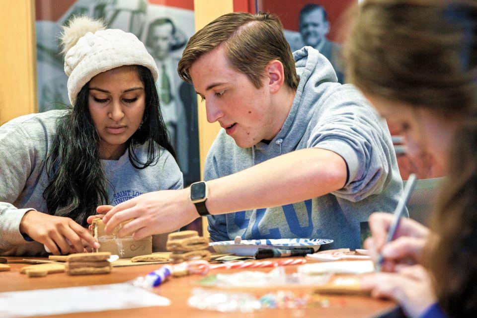 Naveena Mutharasan and Clayton Stout construct their gingerbread house, as Sophia Weaver, right, works on decorations for the SSE Innovation Challenge on December 2, 2024. Photo by Sarah Conroy.