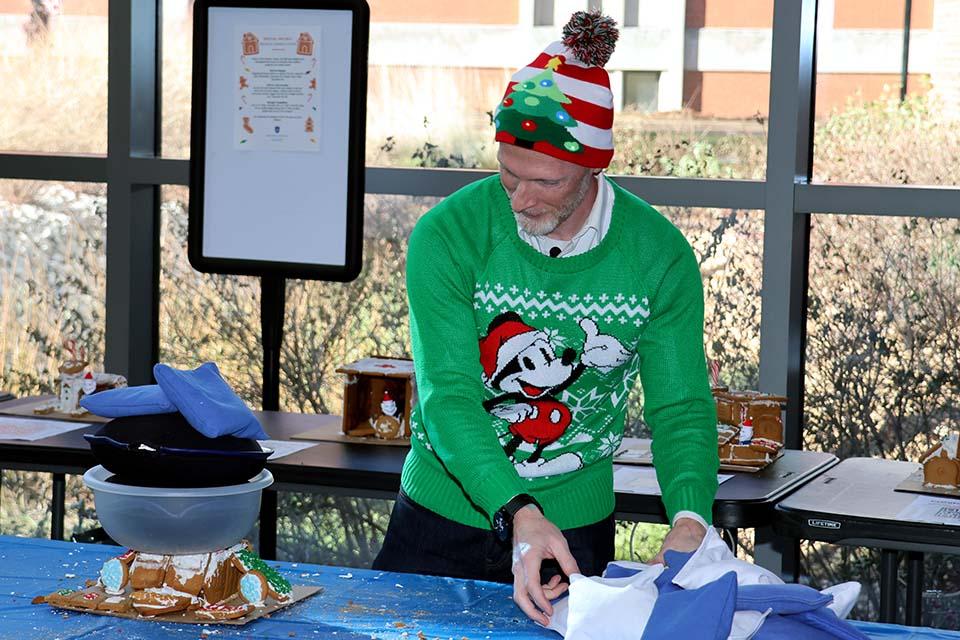 Scott Sell, Ph.D., professor of biomedical engineering and associate dean for undergraduate education in SSE, adds weight to a gingerbread house during the innovation challenge on Friday, Dec. 6. Photo by Joe Barker. 