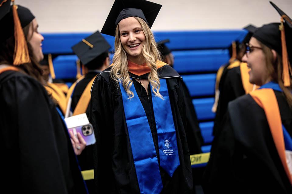 Graduates chat in the practice gym before the Midyear Commencement on Saturday, Dec. 14, 2024. Photo by Sarah Conroy. 