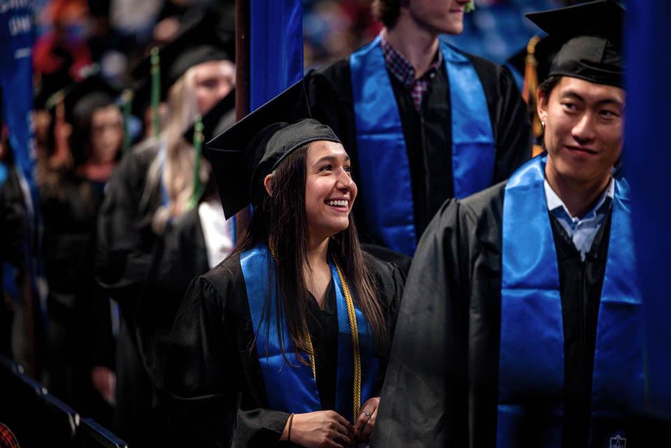 Graduates smile as they walk up to receive their diplomas during the Midyear Commencement on Saturday, Dec. 14, 2024. Photo by Sarah Conroy. 