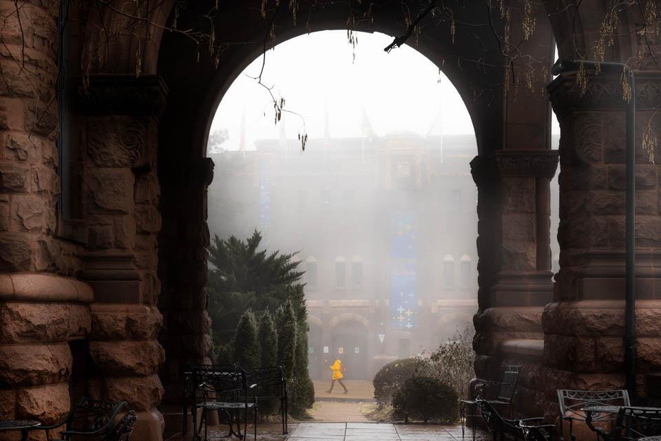 A person walks past the Samuel Cupples House during a foggy day on Jan. 24, 2024. Photo by Sarah Conroy. 