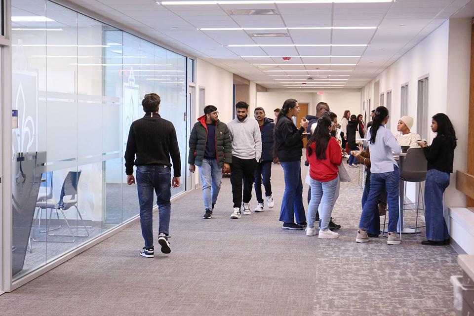 The longest hallway on the second floor of the Wool Center fills with students in between classes and is a gathering space for students.