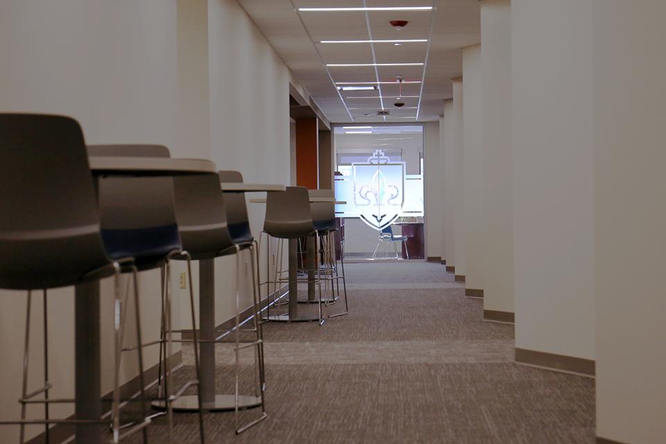 The SLU logo can be seen down a long hallway with angled and sitting arrangements. 
