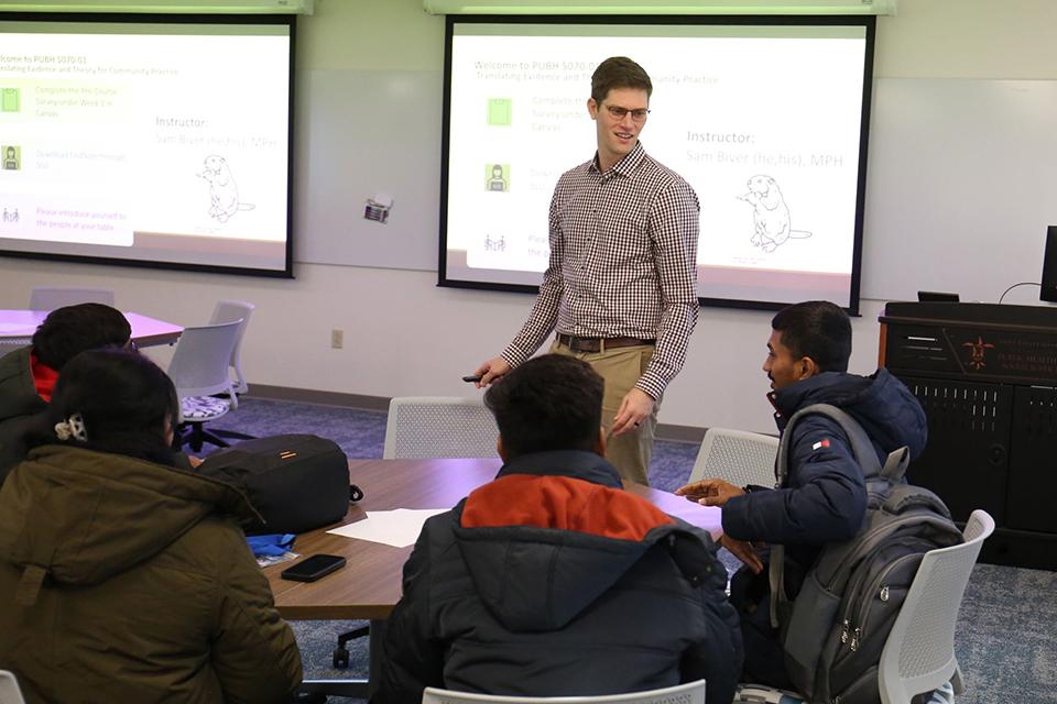 Instructor Sam Biver teaches a full classroom on the first day of class in Room 294 on the second floor of the Wool Center.