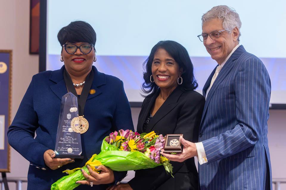 LaTonia Collins-Smith, Ed.D, recipient of the Dr. Fred Pestello Leadership for Justice & Service Award, left, poses with Rochelle D. Smith, vice president of the Division of Diversity and Innovative Community Engagement and President Fred P. Pestello, Ph.D., during the Martin Luther King Jr. Memorial Tribute on January 23, 2025. Photo by Sarah Conroy. 