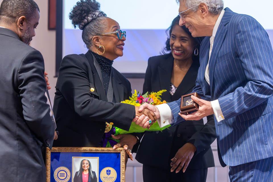 Regina Belle, recipient of a Civic Leadership Award, center left, is congratulated by Rochelle D. Smith, vice president of the Division of Diversity and Innovative Community Engagement, and President Fred P. Pestello, Ph.D., during the Martin Luther King Jr. Memorial Tribute on Jan.  23, 2025. Photo by Sarah Conroy.