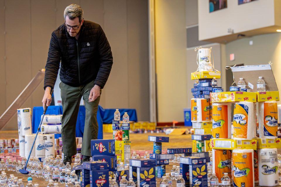 Members of the SLU community play miniature golf on a course constructed from shelf-stable grocery items at Golf and Give, an SSE Innovation Challenge to benefit Billiken Bounty on February 25, 2025. Photo by Sarah Conroy.