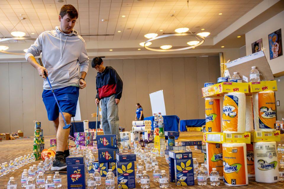 Members of the SLU community play miniature golf on a course constructed from shelf-stable grocery items at Golf and Give, an SSE Innovation Challenge to benefit Billiken Bounty on February 25, 2025. Photo by Sarah Conroy.