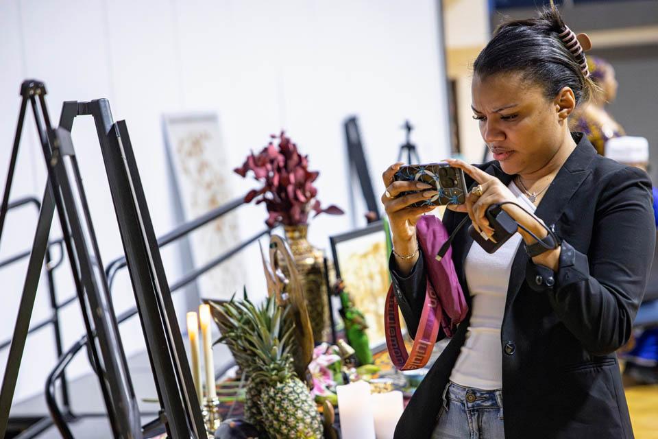 An attendee takes photos of the display of personal items during the Lights of Remembrance Candlelight Vigil on Thursday, Feb. 27, 2025. Photo by Sarah Conroy.