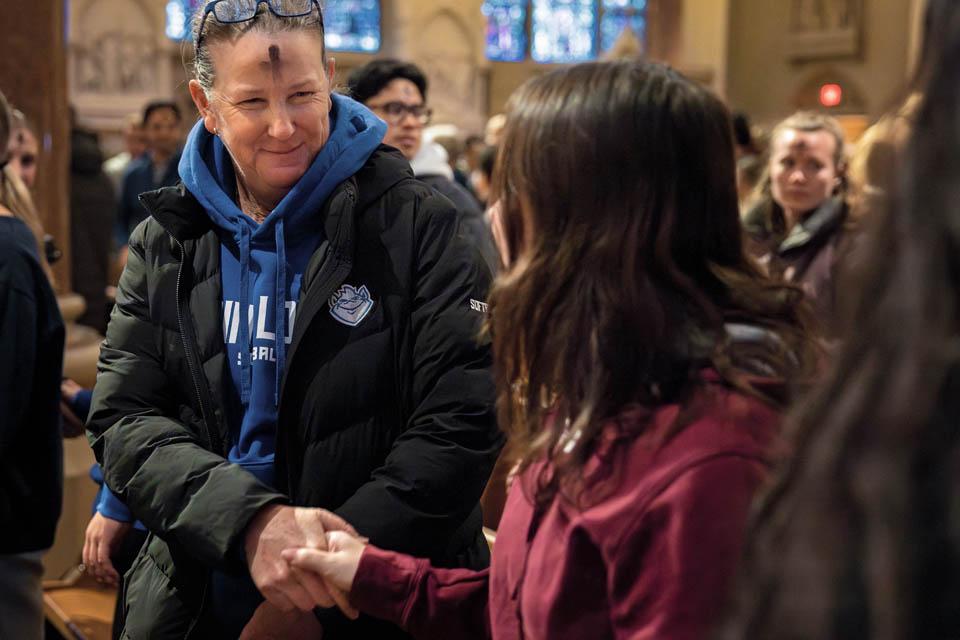 Members of the SLU community share the sign of peace during Ash Wednesday Mass at St. Francis Xavier College Church on March 5, 2025. Photo by Sarah Conroy. 