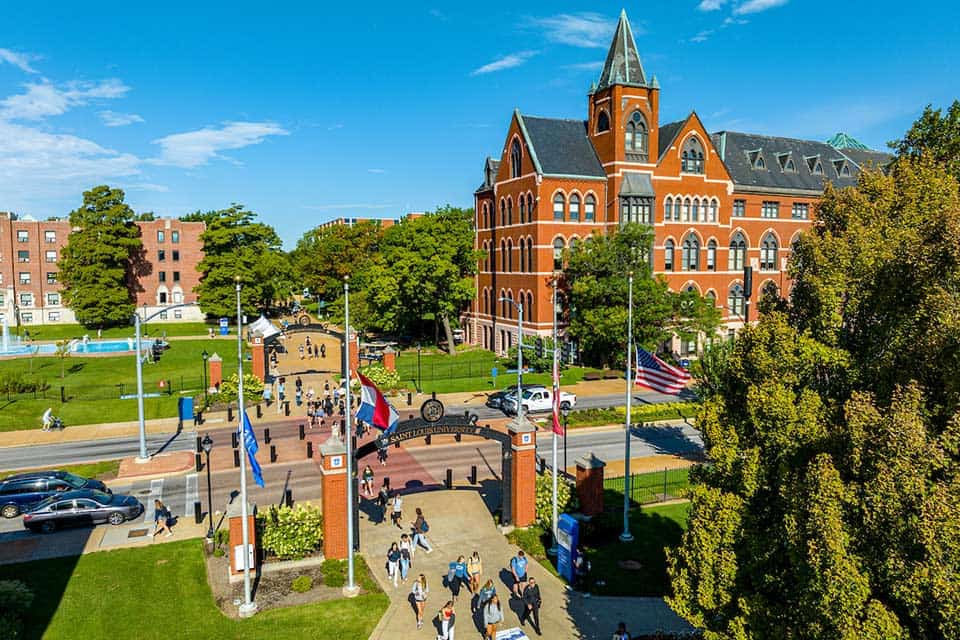 Campus beauty shot of Cook Hall An aerial view of SLU and Grand Boulevard. Students cross the street at the crosswalk.