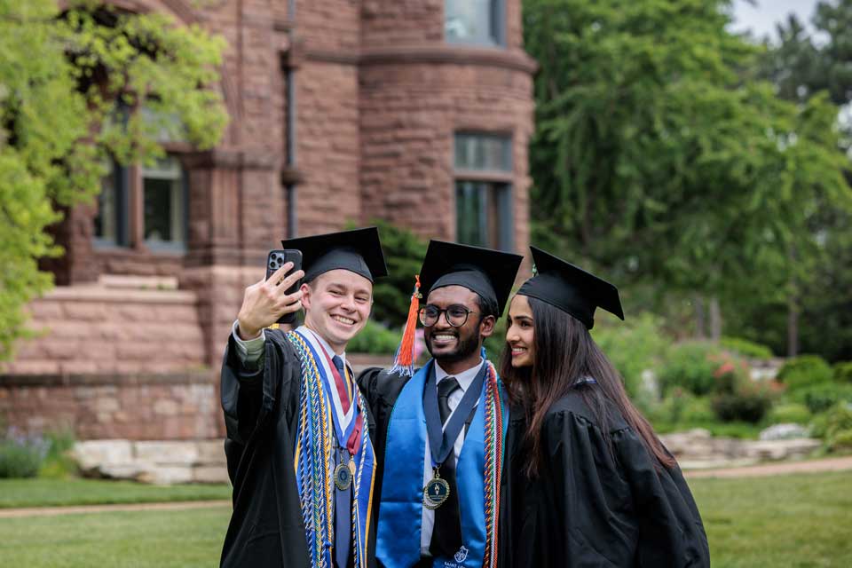 Three SLU grads takng a photo together