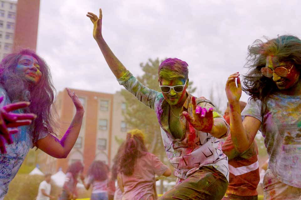 Students dancing together covered in paint.