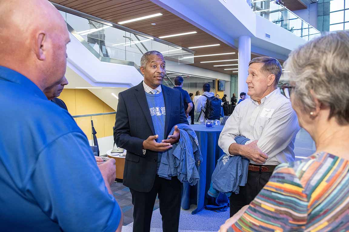 The dean of SLU's School of Science and Engineering talks with attendees at an open house