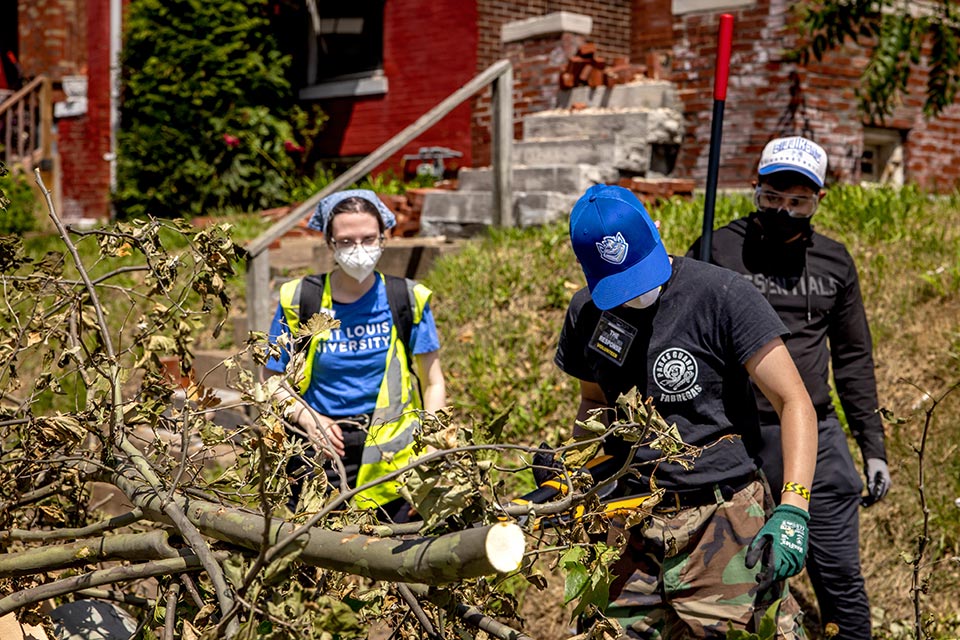 Tornado Cleanup Three people clean up tree debris.
