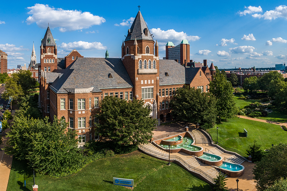 Cook Hall exterior on a sunny day, with a large fountain and steps in front.