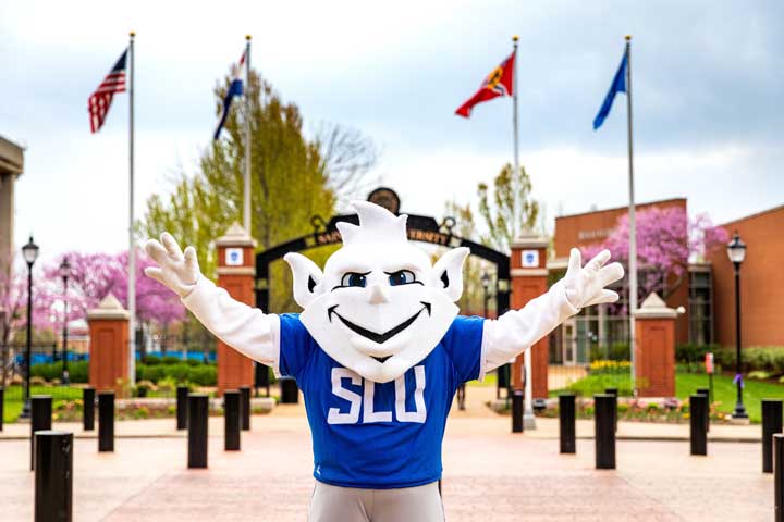SLU's mascot, the Billiken, in front of a campus gateway 