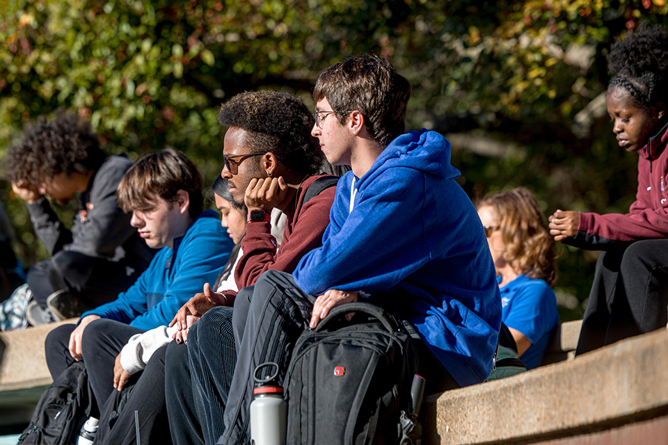 Students sit on the steps of the amphitheater.