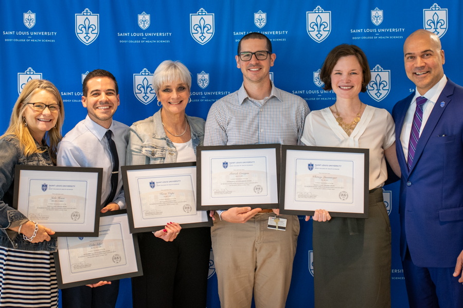 DCHS faculty standing with certificates