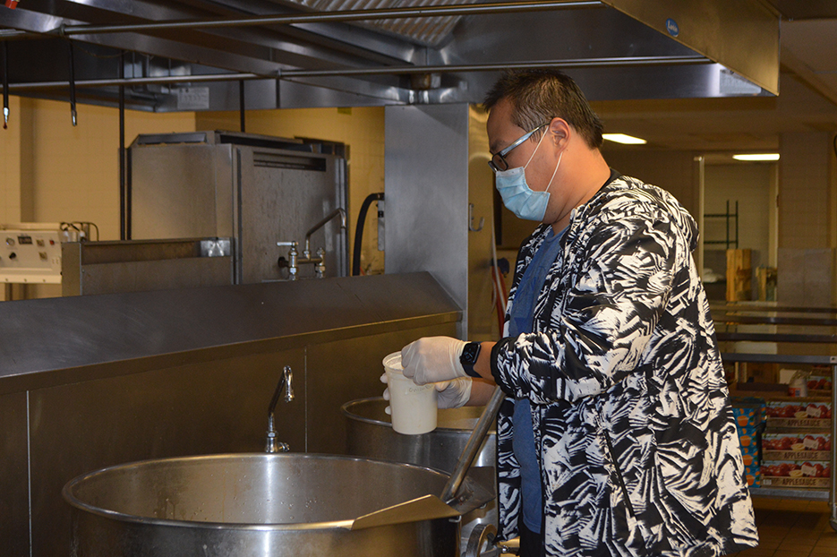 Student cooking lunches for school lunch program