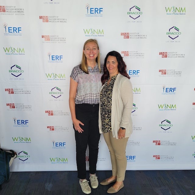 Crystal Botkin and Sarah Frye standing in front of a white backdrop together at the conference