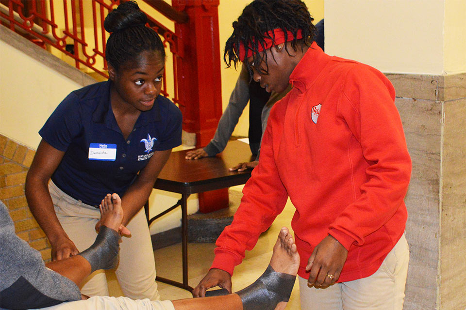 SLU athletic training student tapes an ankle