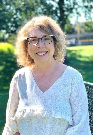 Jeannine Butler, Ed.D., wearing glasses and a white blouse smiles in this headshot.