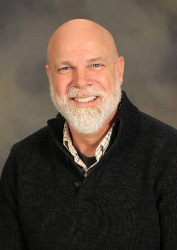 Robert Vogelaar, Ed.D., wearing a black sweater over a button-down shirt, smiles in this headshot.