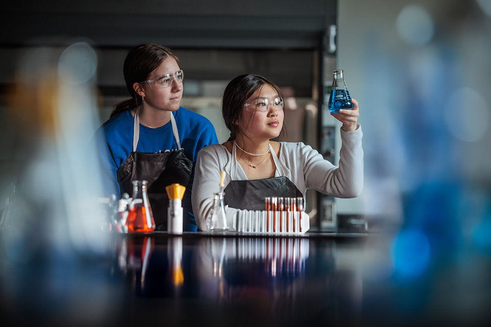 Two women work in a chemistry lab.