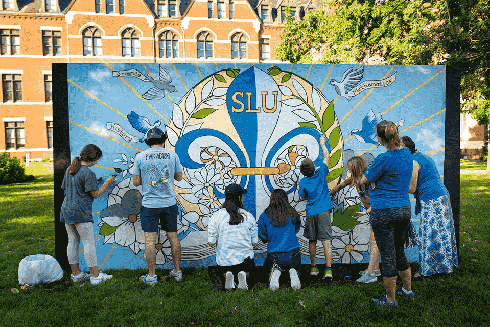 A group of eight students paint a mural together.