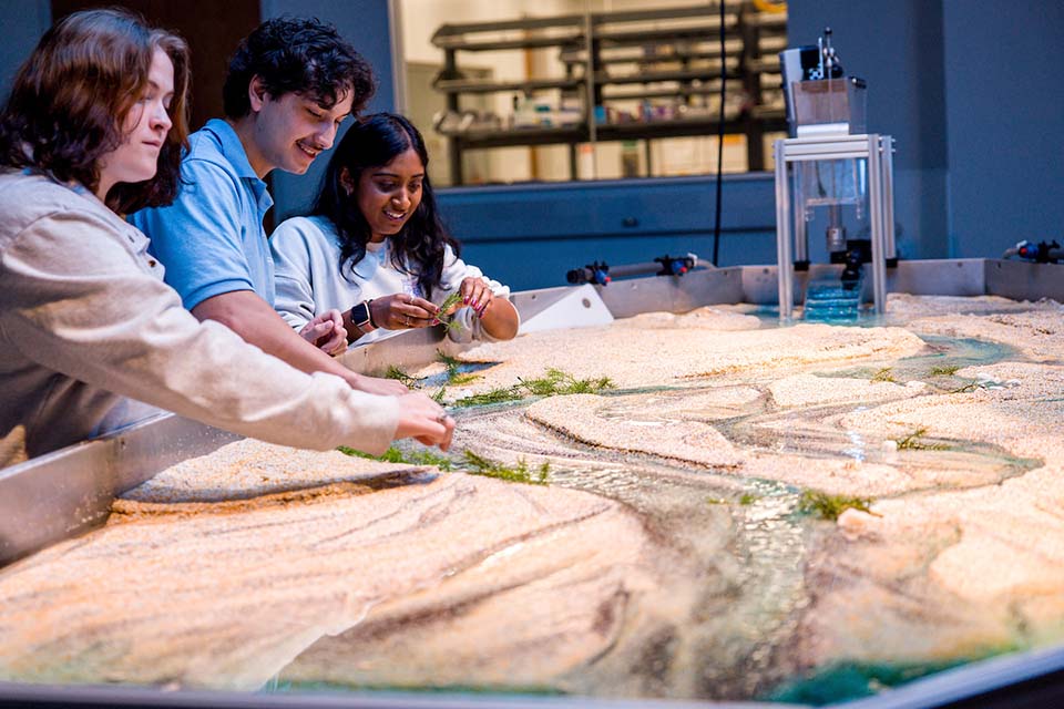 Students work with the Water and Sediment Flume in the WATER Institute at the Interdisciplinary Science and Engineering building.