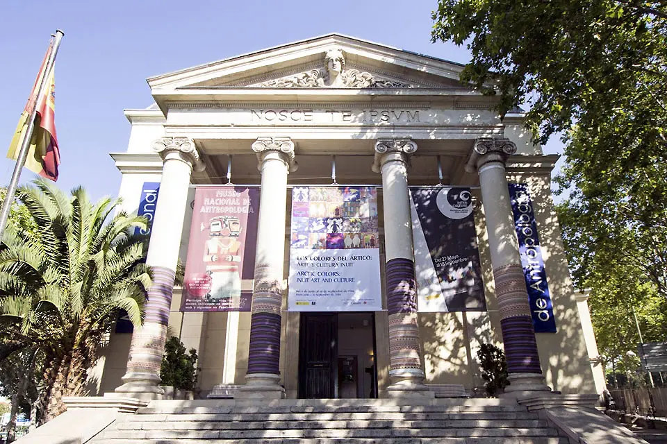 Exterior image of the museum entrance, in a neo-classical style with steps leading up to corinthian columns and banners hanging from the front.
