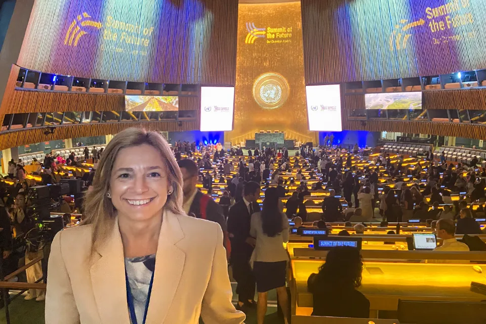 Laura Muro stands with the floor of the United Nations in the background. Graphics read Summit of the Future