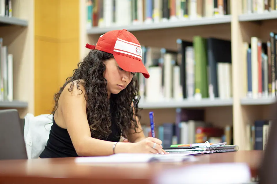 A student writing in a notebook in the library