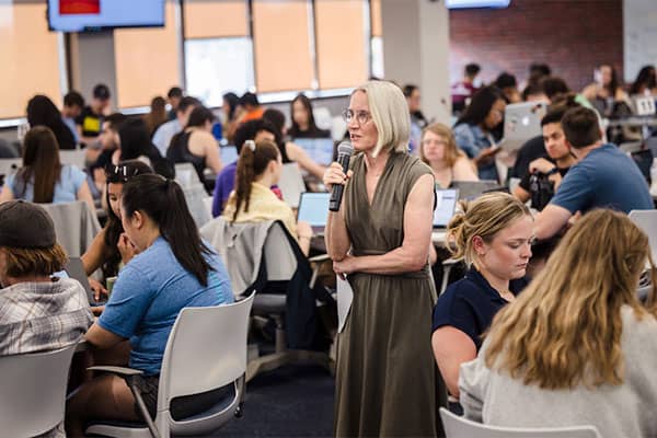 An instructor speaks to a room full of medical professionals during a CME course in SLU’s School of Medicine 360 classroom.