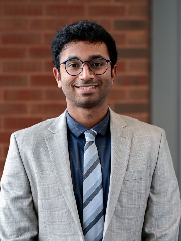 Young, Indian man in grey suit and glasses