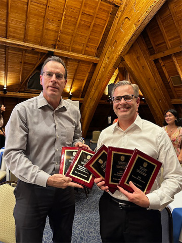 Sean Soretzke and John Martin pose for a photo in Pere Marquette Gallery holding their five awards.