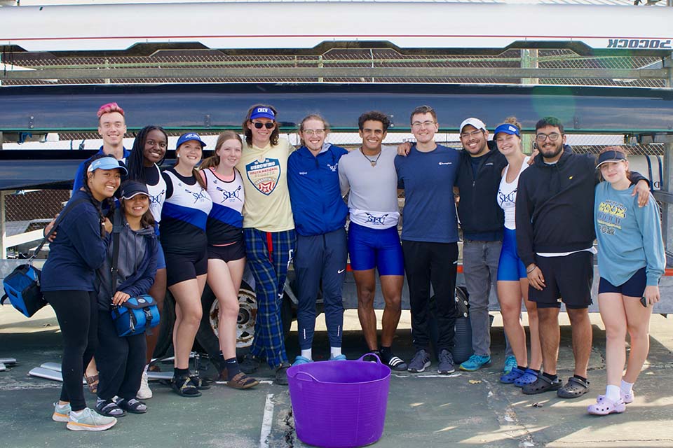 Members of the SLU crew team smile and pose for a photo.