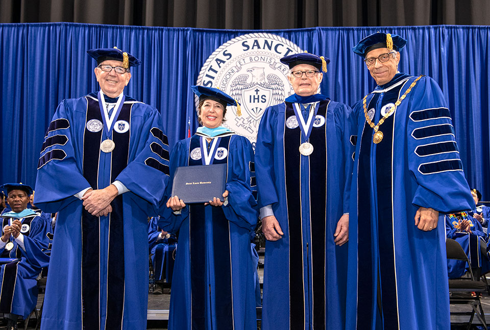 Joseph Conran, chairman of the Board of Trustees, left, honorary degree recipients Joan and John Vatterott, and Fred P. Pestello, during the 2022 Saint Louis University commencement at Chaifetz Arena on May 21, 2022.