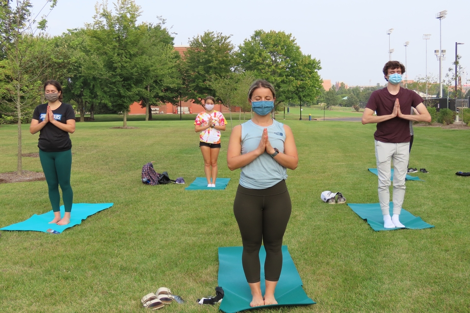 Students and faculty member Asmira Alagic, Ph.D. (center) stand with hands to heart as part of a SLU STEM Wellness yoga session.