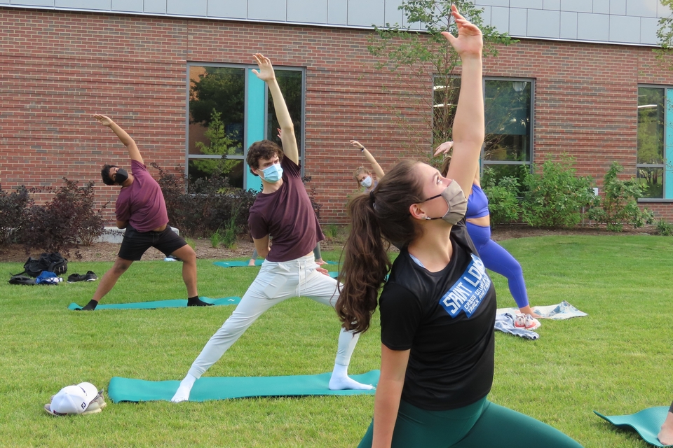 Students move through poses at a SLU STEM Wellness Initiative outdoor yoga session on Sept. 17, 2020.