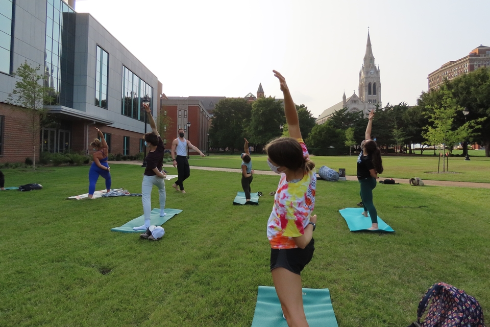 Students bend back in a pose at a SLU STEM Wellness yoga event.